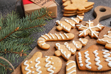 Fototapeta na wymiar Board with Christmas gingerbread cookies on dark background