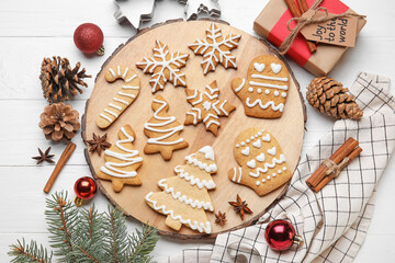 Board with Christmas gingerbread cookies on white wooden background
