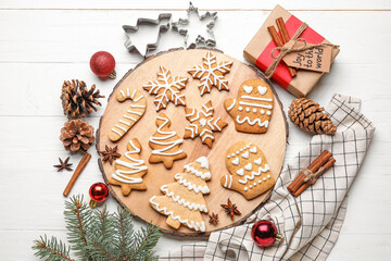 Board with Christmas gingerbread cookies on white wooden background