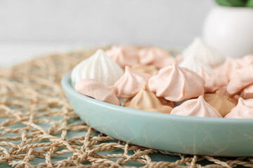 Plate with tasty meringues on table, closeup