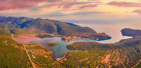 Amazing summer view from flying drone of Limin Ieraka village. Great sunrise on Peloponnese peninsula, Greece. Colorful morning seascape of Myrtoan Sea. Beauty of nature concept background.