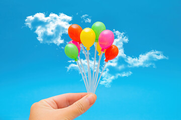 Cluster of colorful balloons against sky background