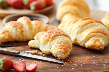 Board with fresh croissants on table