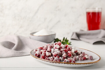 Plate with sugared cranberry on table