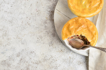 Wooden board with tasty vegetable pot pies on light background