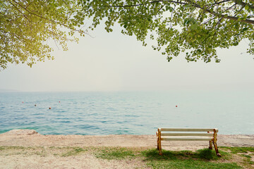 Fototapeta na wymiar Beautifil landscape with bench on the sea shore.