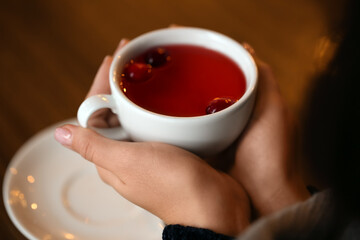 Young woman drinking tea at table in cafe