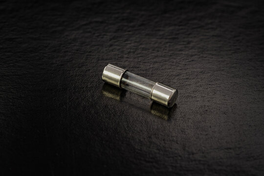 Blown cartridge electrical fuse on a black background