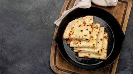 Crepes with sweet toppings on dark background.