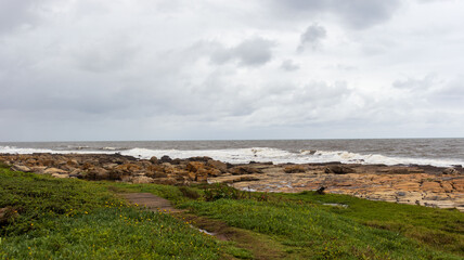 Fototapeta na wymiar A view of the sea with a rocky embankment on the coastline of South Africa