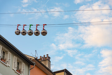 The famous colored cablecar in Grenoble, European Alps, France, running over the roof of residential buildings. Blue sky with white clouds on the background.