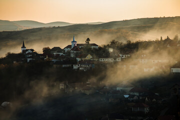  Sic, Romania. Foggy sunset over the small village, Transylvania.