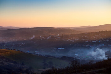  Sic, Romania. Foggy sunset over the small village, Transylvania.