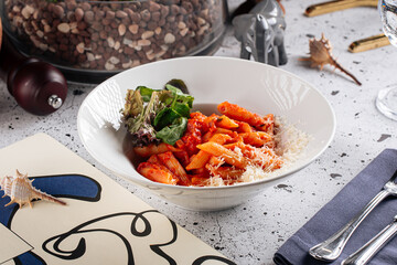 Italian arabiatta penne pasta dish on decorated background