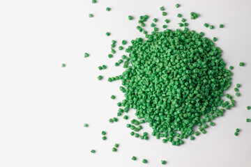 green granules of polypropylene or polyamide on a white background. Plastics and polymers industry. Copy space. Macro