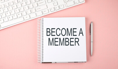 Pink office desk with keyboard and notebook with text BECOME A MEMBER