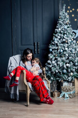 Young mother hugs daughter in pajamas holding her in her arms