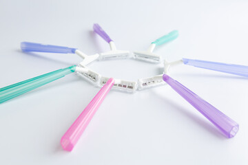 Set of multi-colored disposable razors on white background