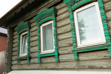 The beautiful old windows with beautifully designed platbands window on an old wooden house in the city of Tula