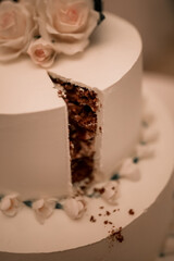 Sweet white wedding cake with cut off piece