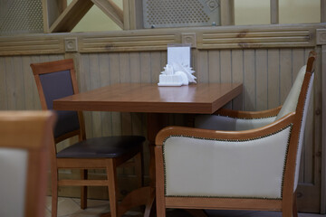 Photo of an empty table in a cafe next to a chair and an armchair cozy and comfortable