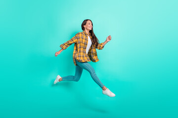 Fototapeta na wymiar Full body profile photo of young active brunette lady run wear shirt jeans sneakers isolated on turquoise background