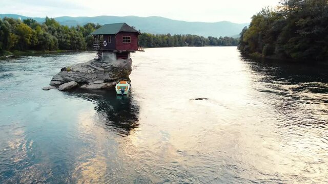 Small wooden cabin on a rock in the middle of river Drina, Serbia.	
