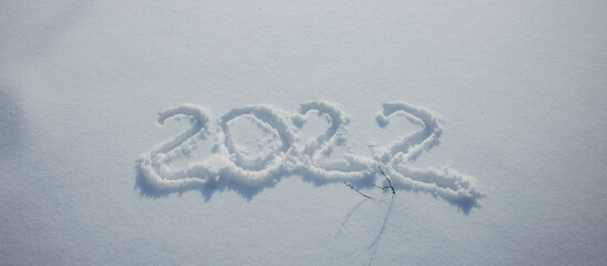 Drawing on white snow. New Year's date, figures 2022, close-up.