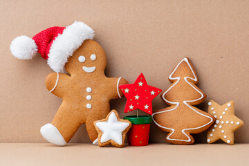 Gingerbread man, cookies and Christmas decor on pastel background.