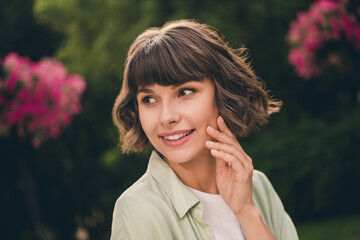 Photo of carefree sweet young lady dressed green shirt backpack walking arm cheek smiling outdoors urban park