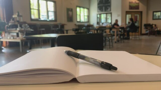 Blank notebook with a pen on a table indoors