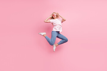 Fototapeta na wymiar Full size photo of funky millennial blond lady jump wear spectacles t-shirt jeans sneakers isolated on pink background