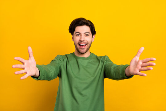 Photo of young happy amazed cheerful man open hands you welcome smile isolated on yellow color background