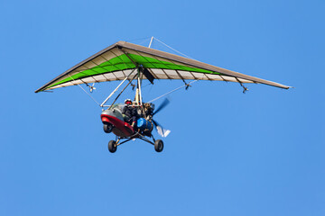 Fototapeta na wymiar Flight on a motorized paraglider in mountainous terrain