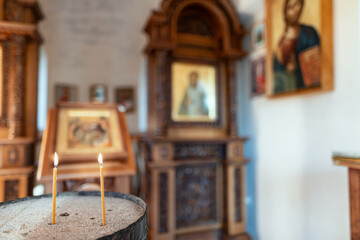 Candles burn in front of the iconostasis and the cross with a crucifix