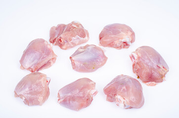 Pieces of cut raw chicken, leg thighs on white background. Studio Photo.