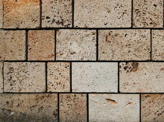 Naklejka premium solid square brickstones from the wall of a fortress - closeup surface of yellow stone bricks texture background