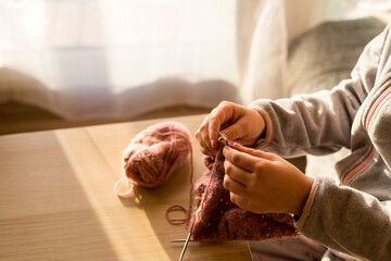 Obraz na płótnie Canvas Woman knitting at home, closeup. Creative hobby. Handmade lifestyle