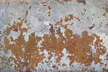 weathered wall with peeling orange paint and chipped over a cement surface with shapes similar to the islands in a map - rough texture for a damaged background of a steampunk wallpaper	