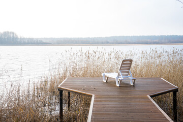 an empty beach chair on the pier
