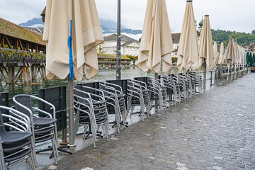 Aufgestappelte Restaurantstühle am Reussufer, Luzern, Schweiz