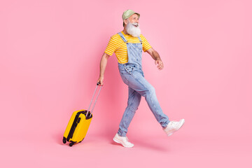Full length body size view of attractive cheerful man carrying bag going abroad isolated over pink pastel color background