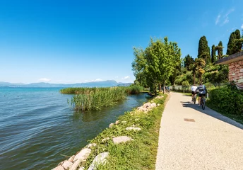 Foto op Canvas Pedestrian and bicycle lane on the coast of Lake Garda that connects the towns of Lazise, Cisano, Bardolino and Garda. Verona province, Veneto, Italy, Europe. On the horizon the coast of Lombardy. © Alberto Masnovo