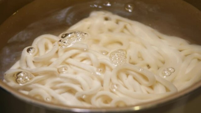 冷凍うどんを沸騰したお湯に入れる動画。