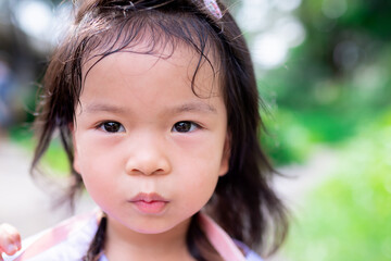 Candid, a cute girl's face with hair drenched in sweat from the heat. In summer or spring.