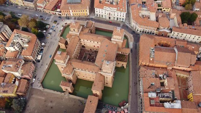 Aerial drone footage of the famous medieval castle in Ferrara old town in Italy. Shot with a downward rotation motion. 
