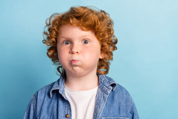 Photo of foolish playful funny little boy puffed inflate cheeks wear denim jacket isolated blue color background - obrazy, fototapety, plakaty