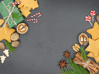 Concrete Christmas background with Christmas gift box, gingerbread cookies, nuts and spices