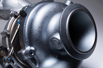 Auto parts new mechanical turbine made of metal on a gray background. Close-up. Mechanical Turbo...