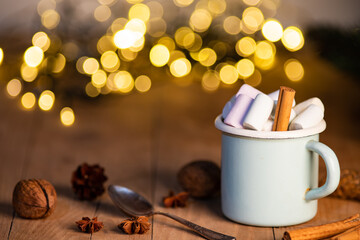 cup of hot chocolate  with marshmallows  cinnamon sticks  cones and branches of spruce. the concept of cozy Christmas and New Year holidays